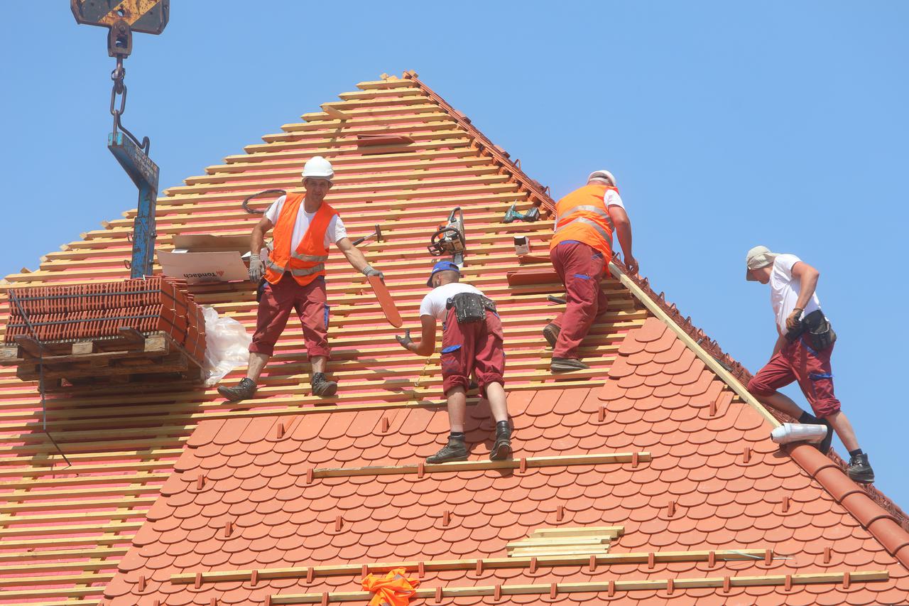 Usprkos jakom suncu i visokim temperaturama radnici postavljaju crijep na krov zgrade u Zvijezdi.