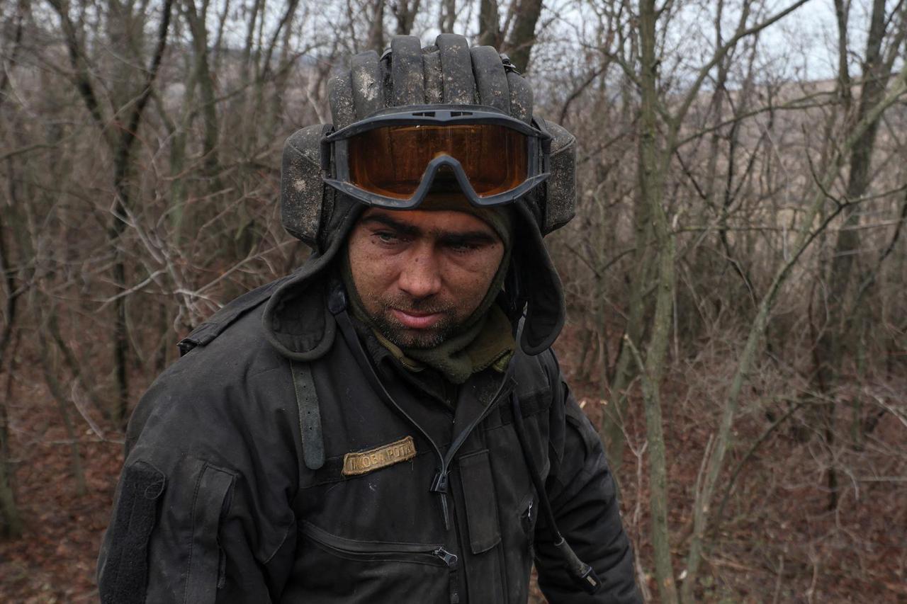 Ukrainian serviceman looks on before driving a tank near the frontline town of Bakhmut