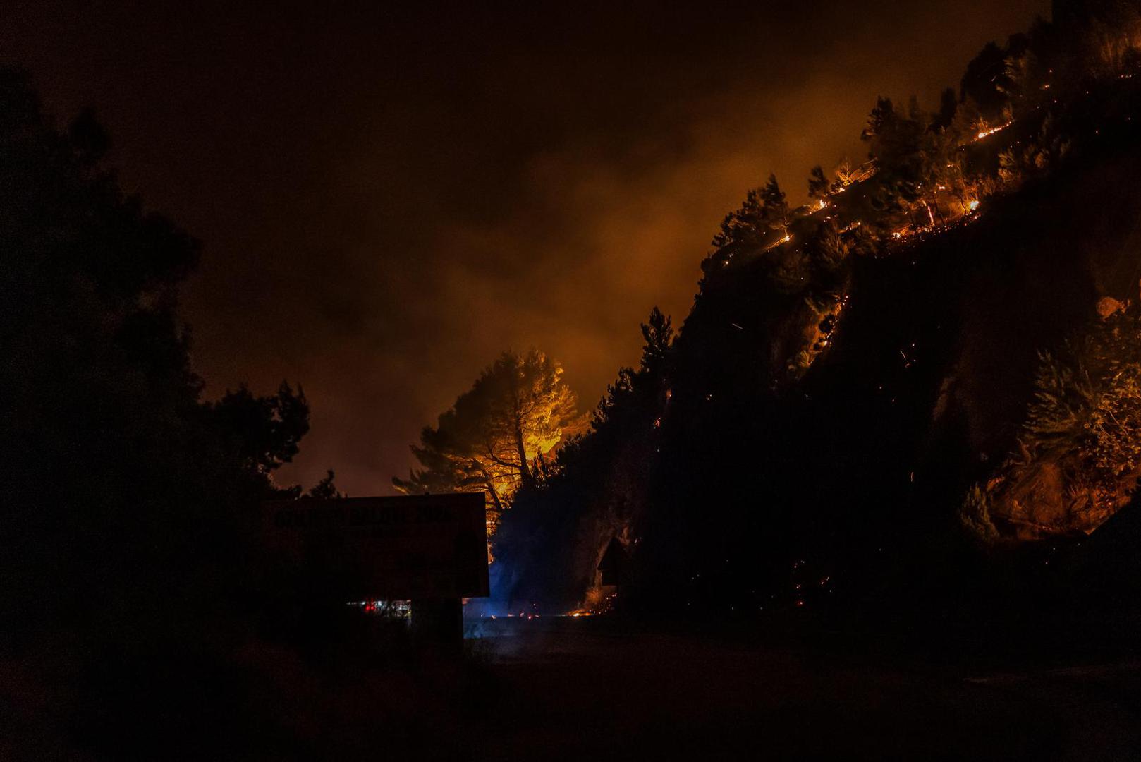 Na snimkama s terena vidi se kako vatrogasci uz samu prometnicu pokušavaju zaustaviti širenje vatre i zaštititi objekte od plamena.