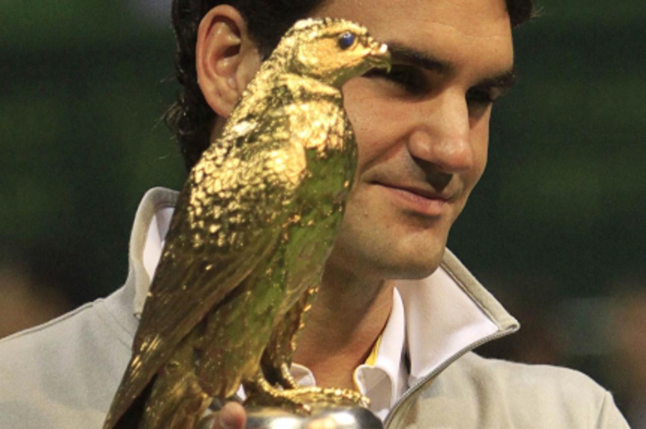 'Roger Federer of Switzerland holds the golden eagle trophy after his final match against Nikolay Davydenko of Russia at the Qatar Open tennis tournament in Doha January 8, 2011. REUTERS/Jamal Saidi (