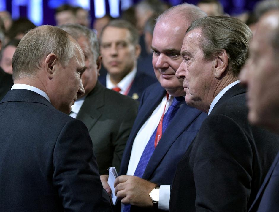 FILE PHOTO: Russian President Putin and former German Chancellor Schroeder, chairman of the shareholders’ committee at Nord Stream AG, attend the Energy Week International Forum in Moscow