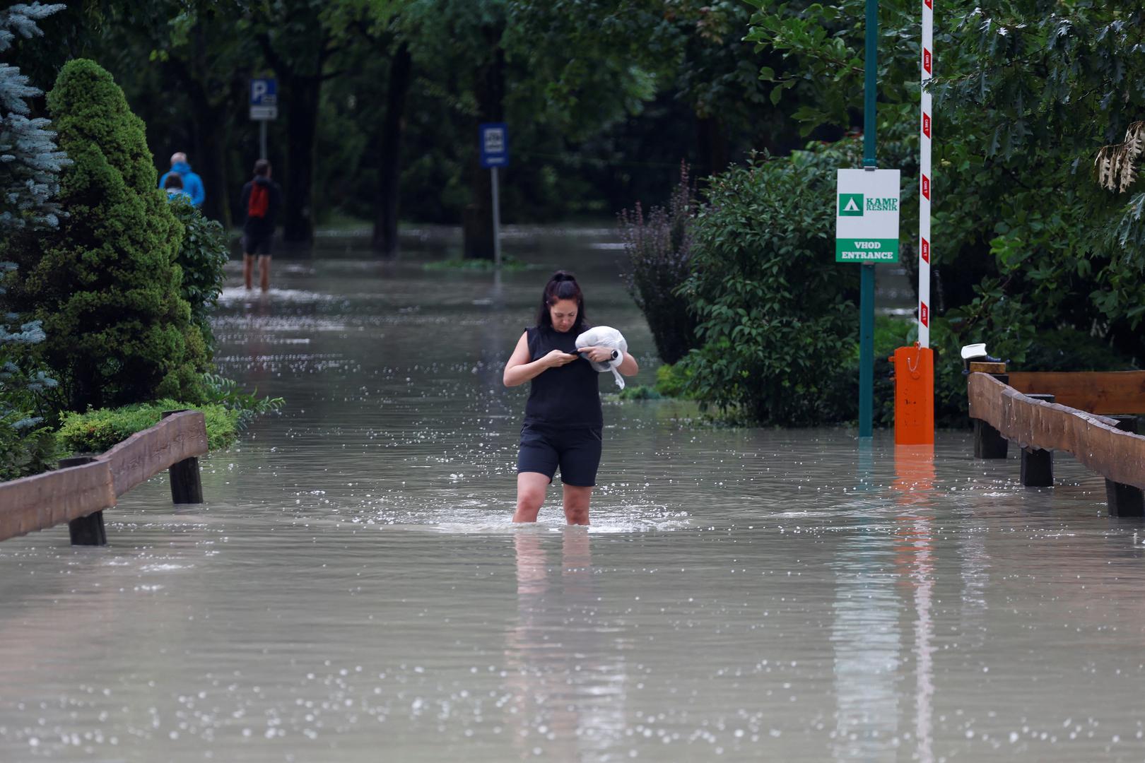A woman wades in water during a flood in Kamnik, Slovenia August 4, 2023. REUTERS/Borut Zivulovic Photo: BORUT ZIVULOVIC/REUTERS