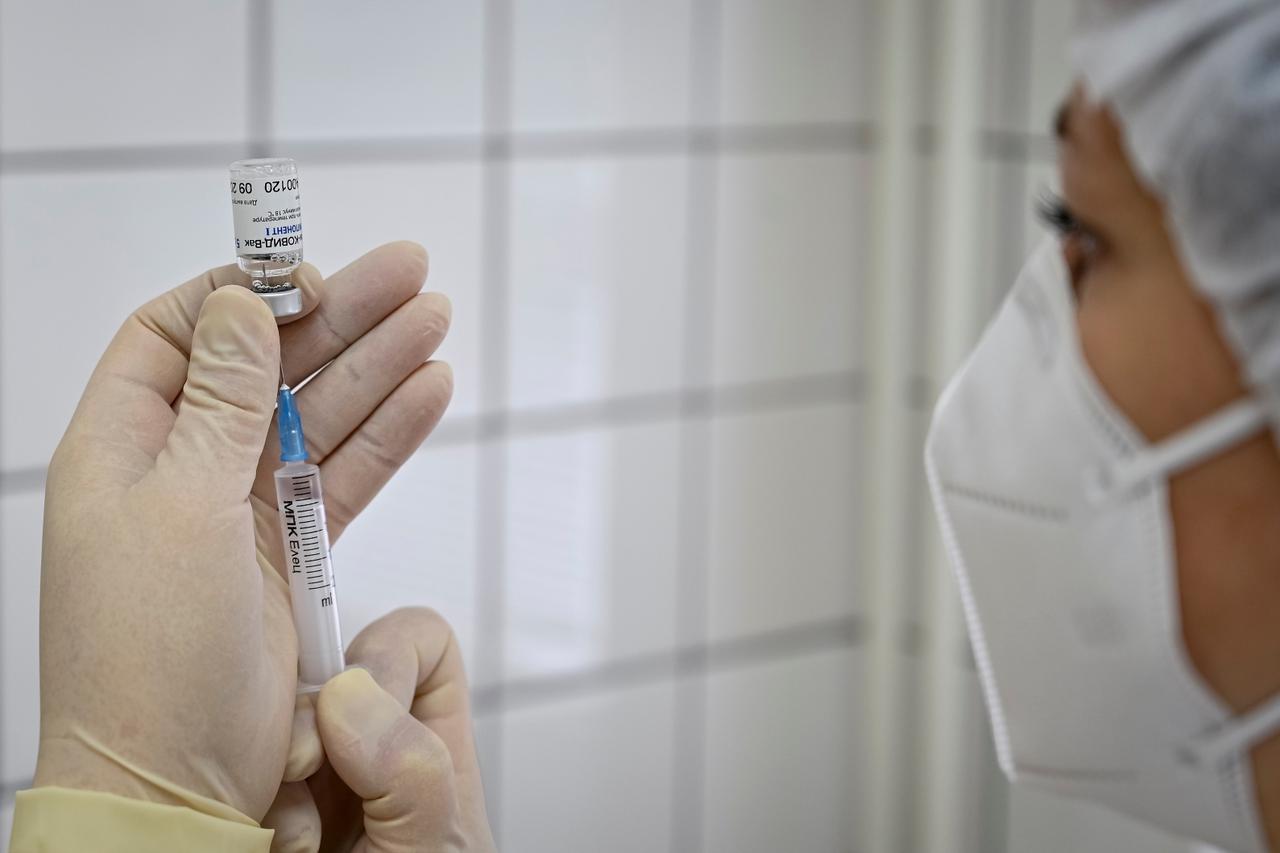 A medical worker fills a syringe with Sputnik V (Gam-COVID-Vac) vaccine as she prepares to vaccinate a Russian Army service member at a clinic in the city of Rostov-On-Don