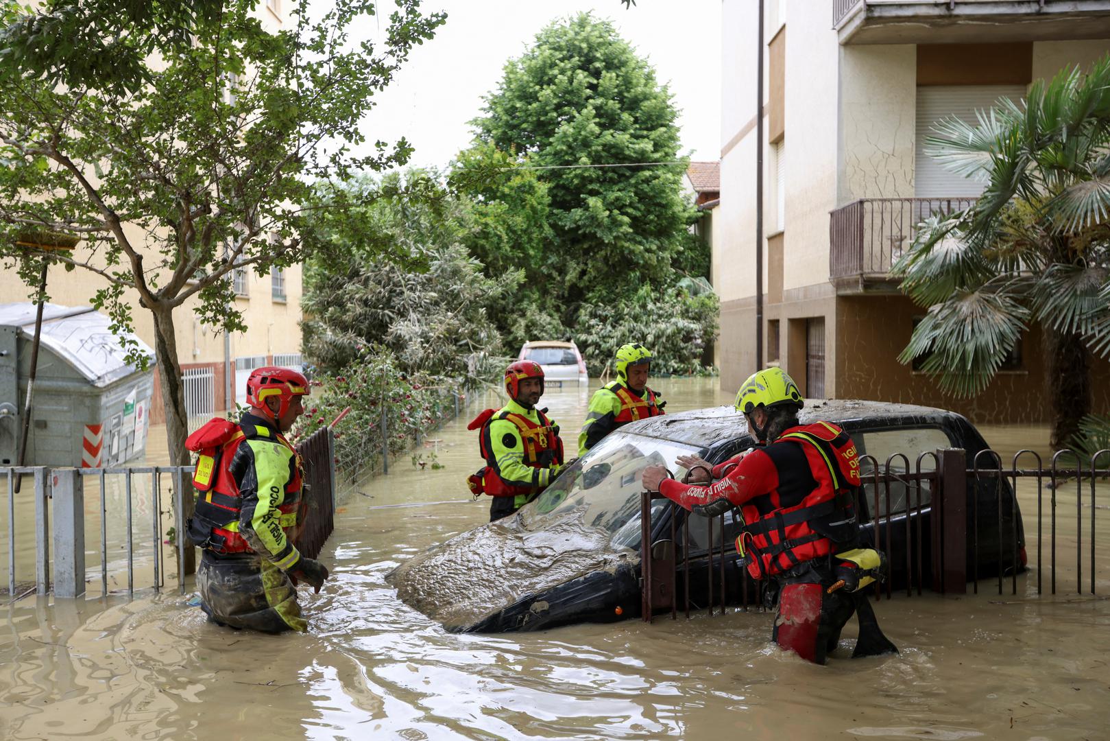 Firefighters work next to a flooded car, after heavy rains hit Italy's Emilia Romagna region, in Faenza, Italy, May 18, 2023. REUTERS/Claudia Greco Photo: CLAUDIA GRECO/REUTERS