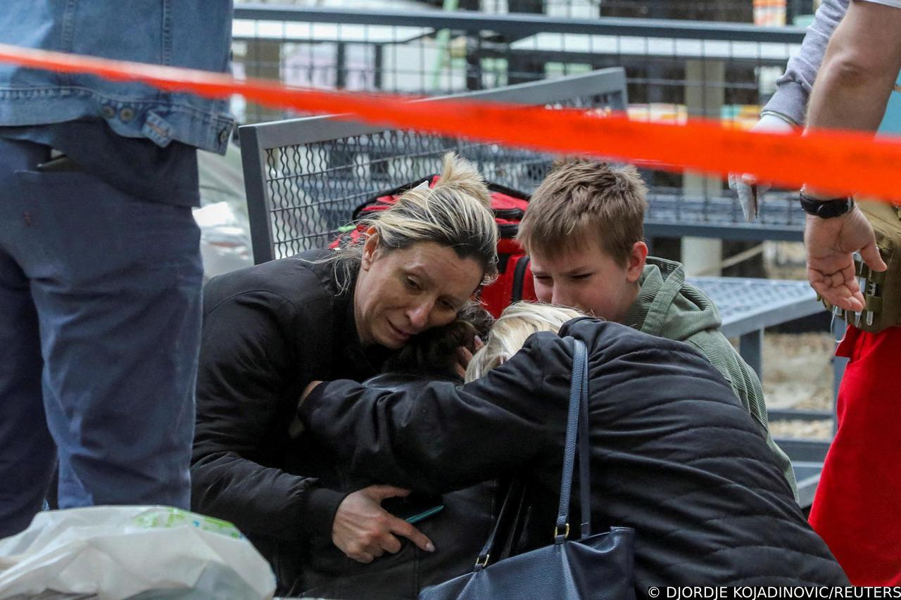 People react after a 14-year-old boy opened fire on other students and security guards at a school in downtown Belgrade