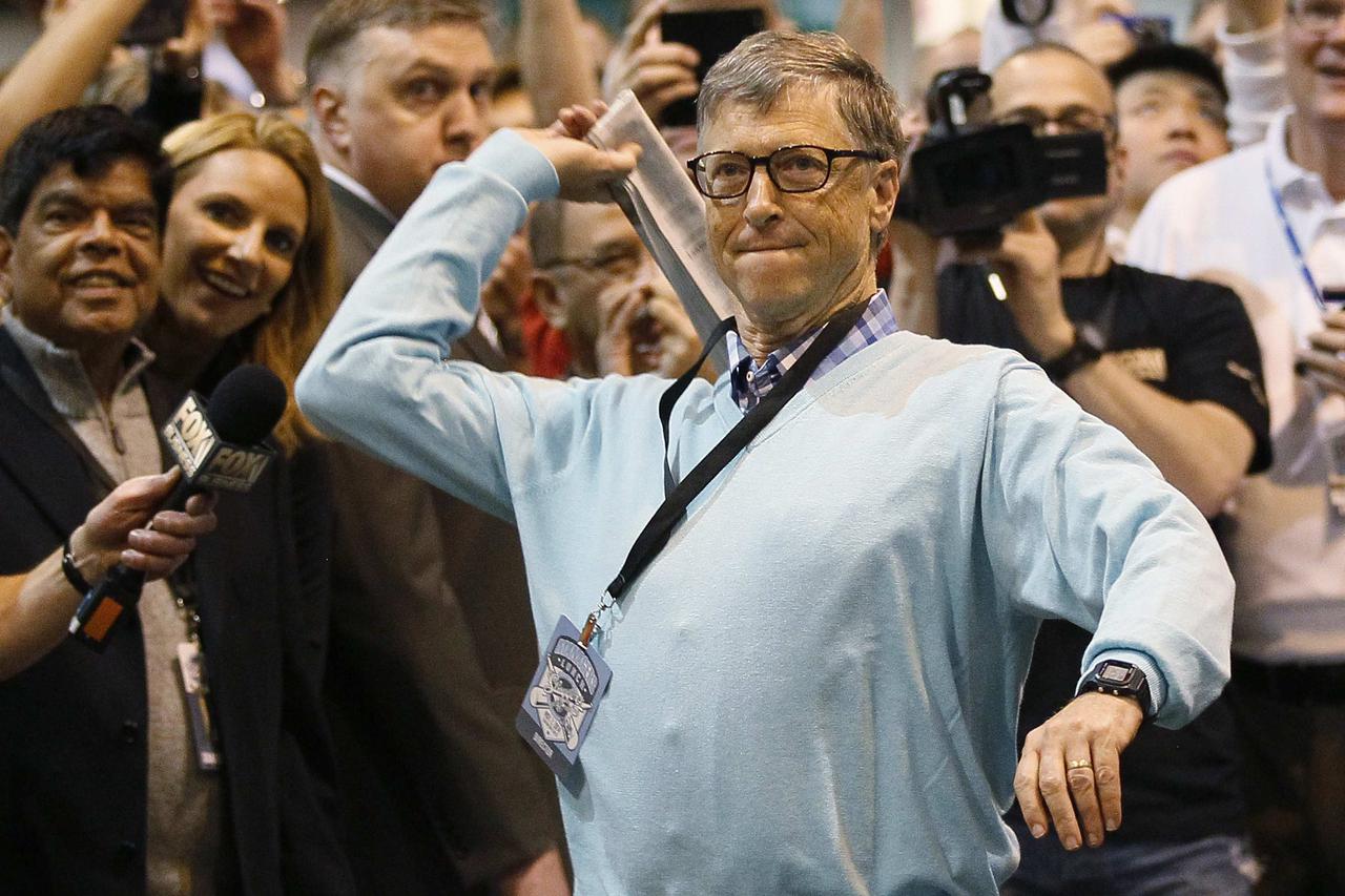 Microsoft founder and technology advisor Bill Gates throws a newspaper during a competition at a trade show, at the Berkshire Hathaway annual meeting in Omaha, Nebraska May 3, 2014. Warren Buffett's Berkshire Hathaway Inc on Friday said quarterly profit d