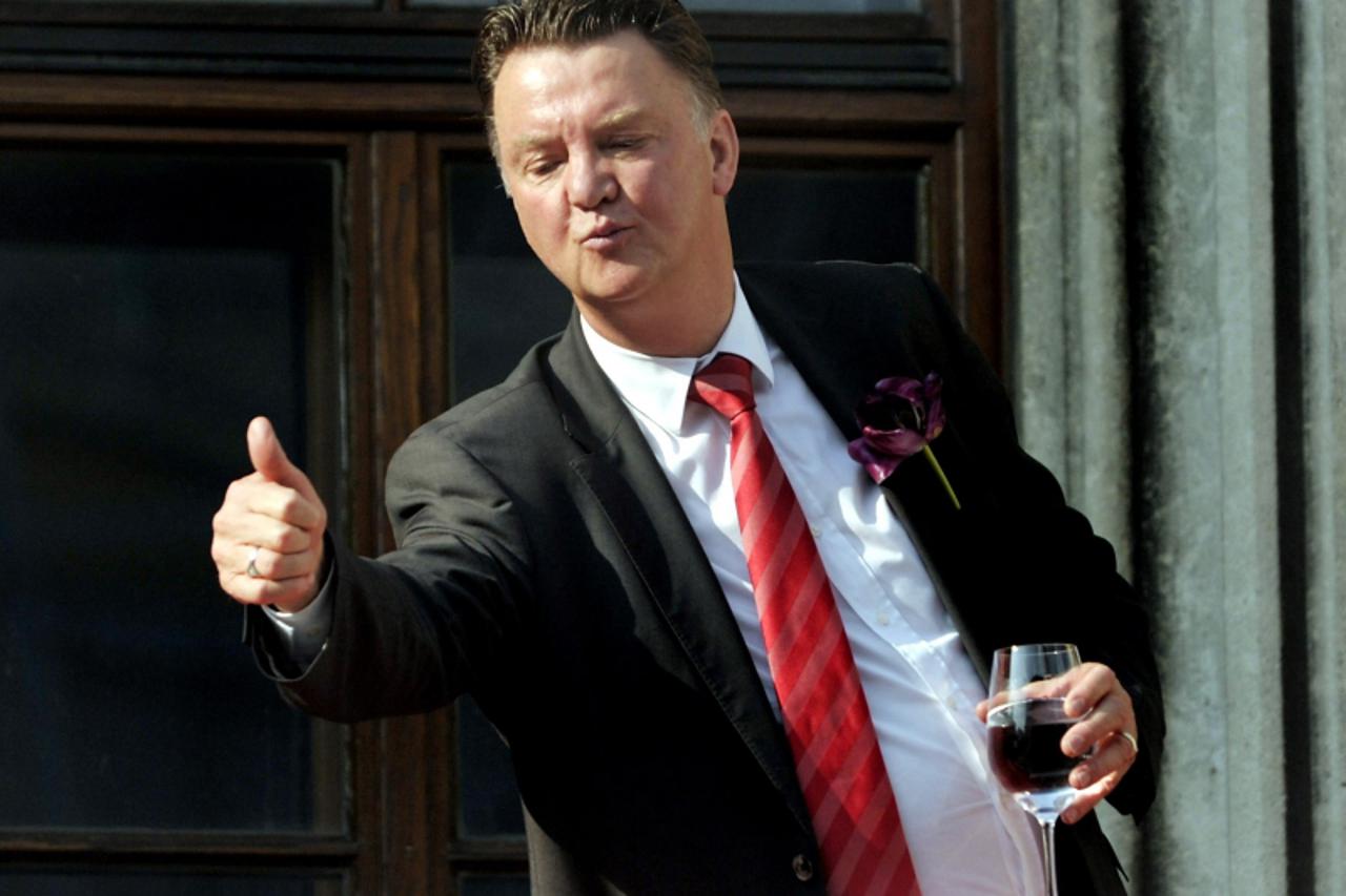 'Bayern Munich\'s Dutch head coach Louis van Gaal gives the thumbs up sign from the balcony of city hall during a celebration party in the southern German city of Munich on May 23, 2010, the day after