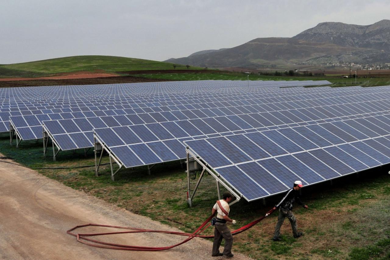'Employees work in  a solar farm  in some 110 kilometers north of Athens on November 11, 2010.With agriculture in Greece facing a bleak future from rising costs and falling produce prices, thousands o