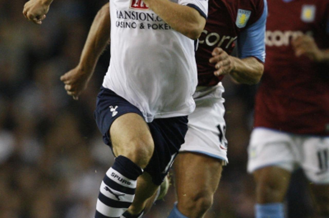 'Tottenham Hotspurs\' Luka Modric (L) runs with the ball in front of Aston Villa\'s Stiliyan Petrov during their English Premier League soccer match at White Hart Lane in London September 15, 2008. RE