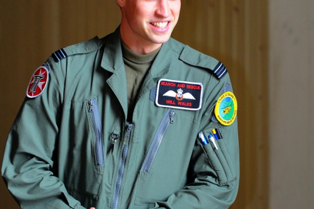 '(FILES) This file picture taken on April 1, 2011 shows Prince William looking on as Britain\'s Queen Elizabeth II leaves after being shown a Sea King helicopter during a visit to RAF Valley in Angles