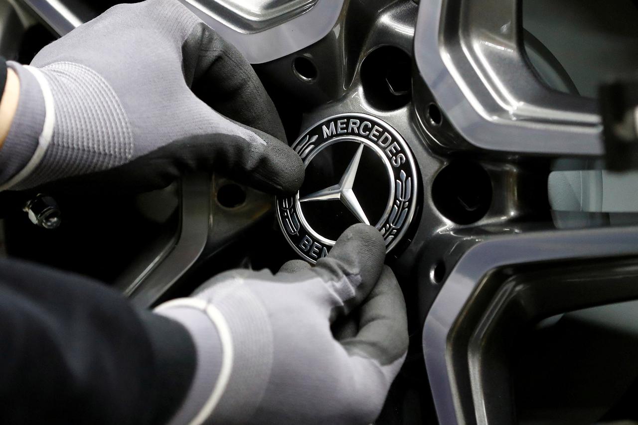 FILE PHOTO: An employee of German car manufacturer Mercedes Benz installs a hubcap at a A-class model at the production line at the Daimler factory in Rastatt