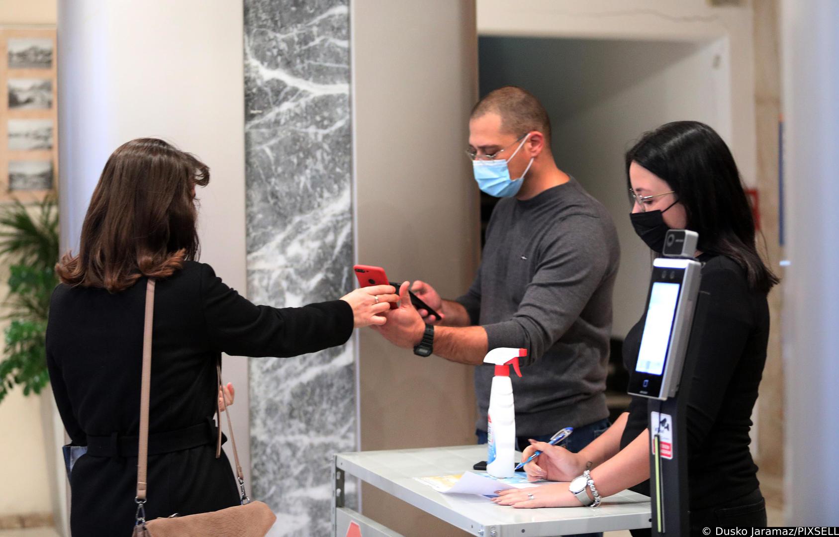 16.11.2021., Sibenik - Prvi je dan obvezne primjene covid potvrda koje dokazuju da je netko cijepljen, da je prebolio covid-19 ili je negativan i od danas postaju obvezne za ulaz u javne i drzavne ustanove. Provjera djelatnika zupanijske uprave i cekanje ispred Fine.  