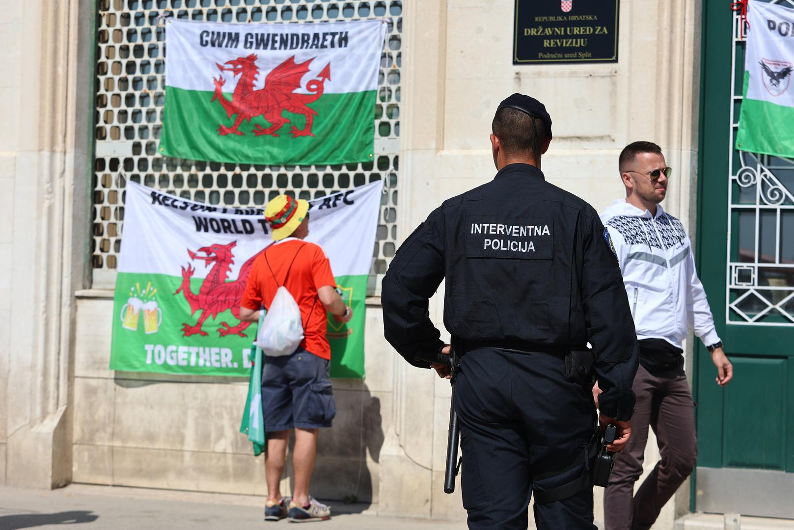 25.03.2023., Split - Navijaci Walesa postavili su svoje navijacke zastave na procelju zgrade na splitskoj Rivi. U jednom trenutku pripadnici interventne policije krenuli su uklanjati zastave, a kada su to vidjeli navijaci oni su ih sami odlucili skinuti. Photo: Miroslav Lelas/PIXSELL