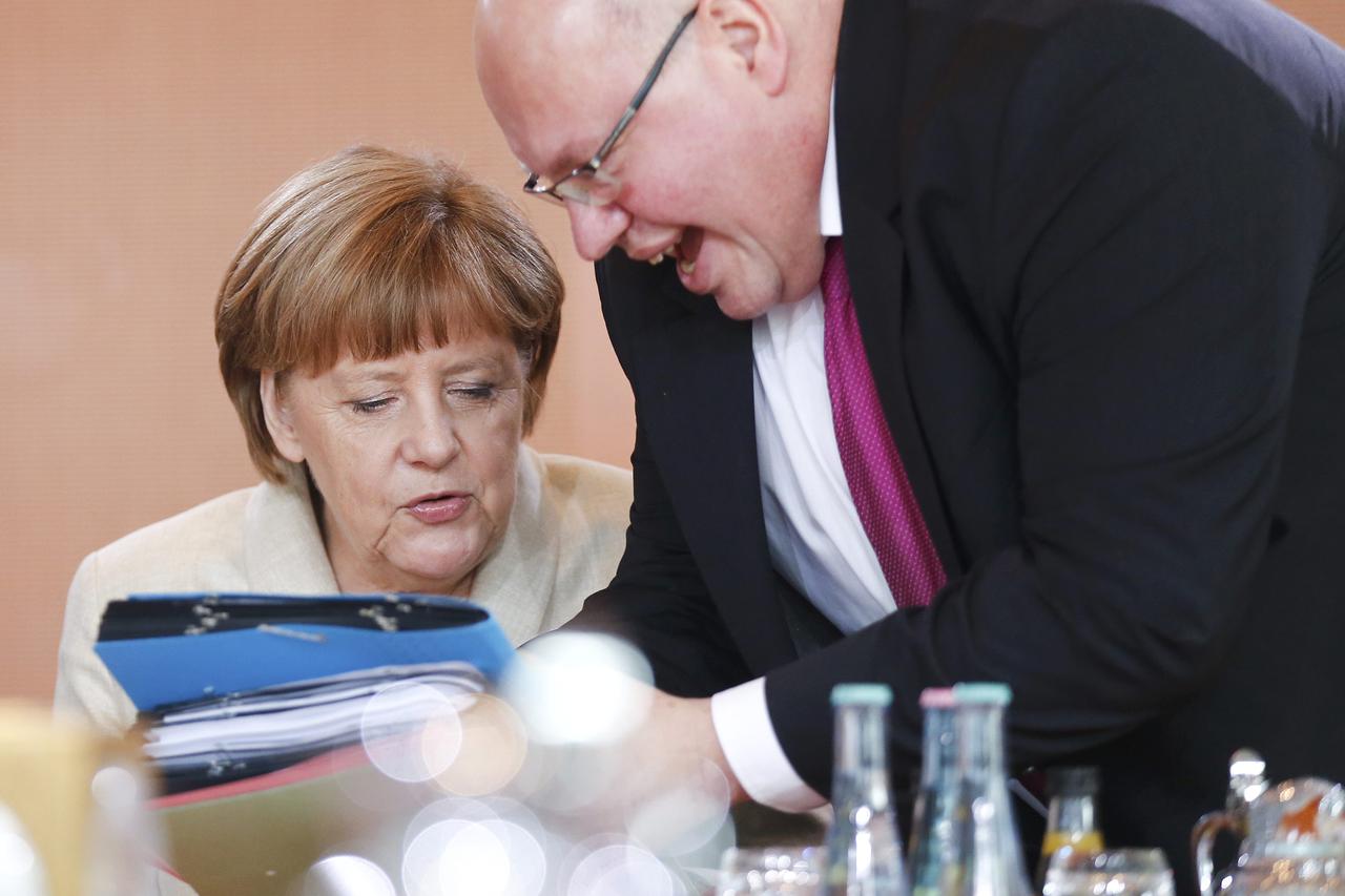 German Chancellor Angela Merkel (L) talks with head of the Federal Chancellery Peter Altmaier during the weekly cabinet meeting at the Chancellery in Berlin, Germany, April 13, 2016.  REUTERS/Hannibal Hanschke