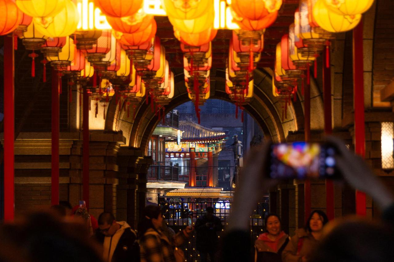 People take images in a side street decorated for the Lunar New Year, in Beijing