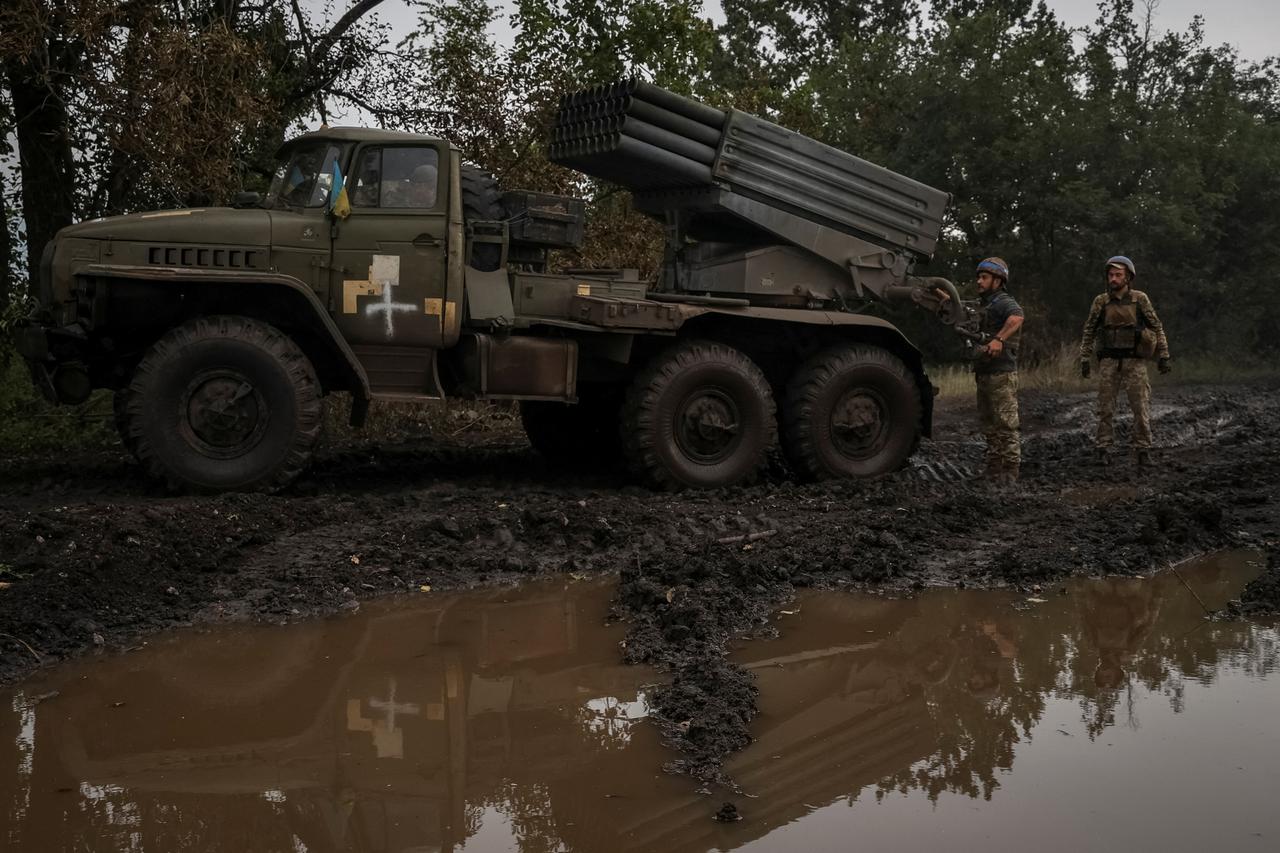 Ukrainian servicemen prepare to fire a BM-21 Grad multiple launch rocket system towards Russian troops near a front line in Donetsk region