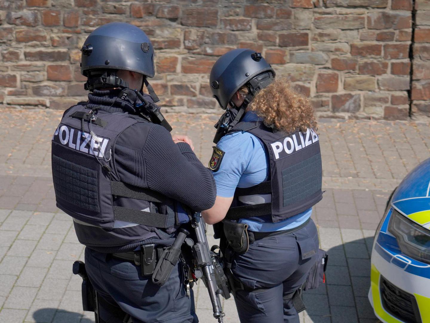dpatop - 08 May 2026, Rhineland-Palatinate, Sinzig: Police officers stand near the scene of an incident. According to initial police reports, a hostage situation has occurred at a bank branch in Sinzig, Rhineland-Palatinate. The emergency services are on the scene with a large contingent in the Ahrweiler district. Photo: Sascha Ditscher/dpa Photo: Sascha Ditscher/DPA