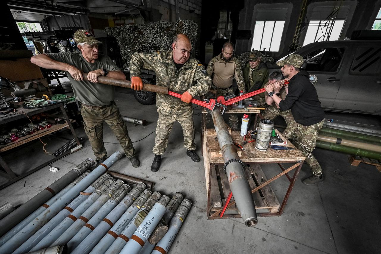 Members of company tactical group "Steppe Wolves" disassemble a shell for a BM-21 Grad multiple launch rocket system to convert it for use with a handmade small MLRS for firing toward Russian troops in Zaporizhzhia region