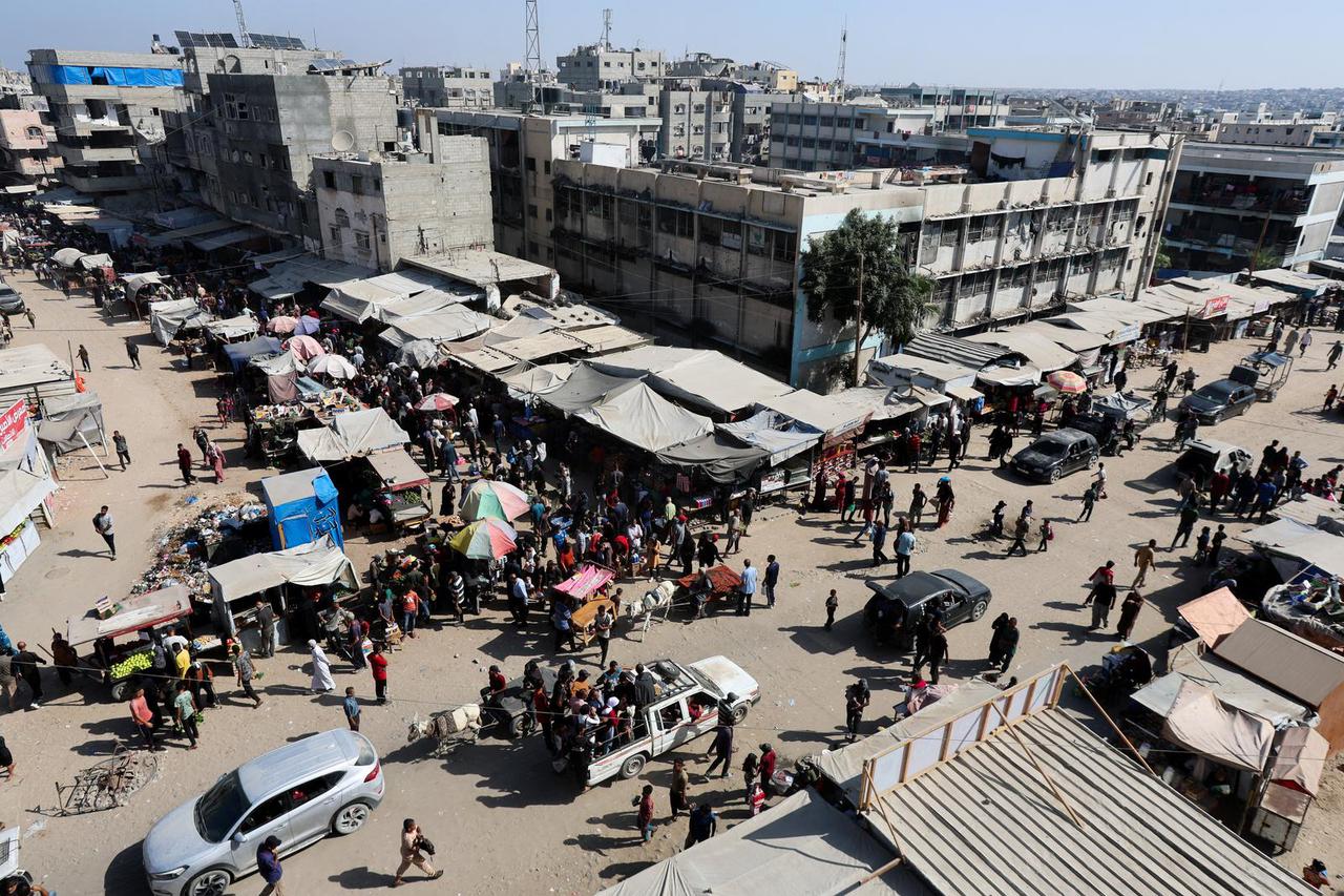 Palestinians shop at a market, amid a ceasefire between Israel and Hamas, in Khan Younis