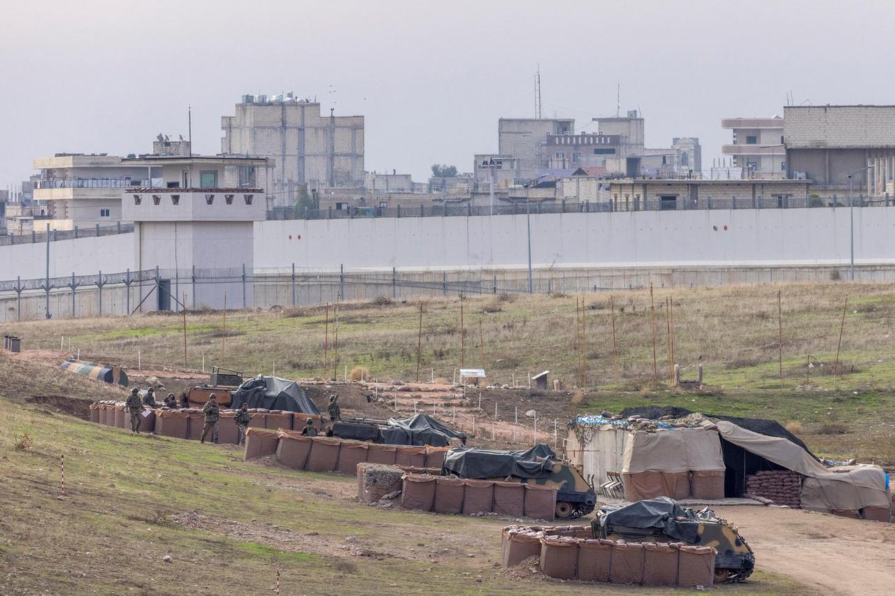 Turkish army vehicles are positioned at a military post as Syrian border town of Jarablus is seen behind  the Turkish-Syrian border line in Karkamis