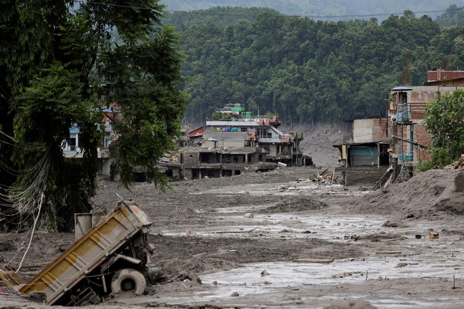 Mud covers houses and a road following a flash flood at Trishuli, Nepal