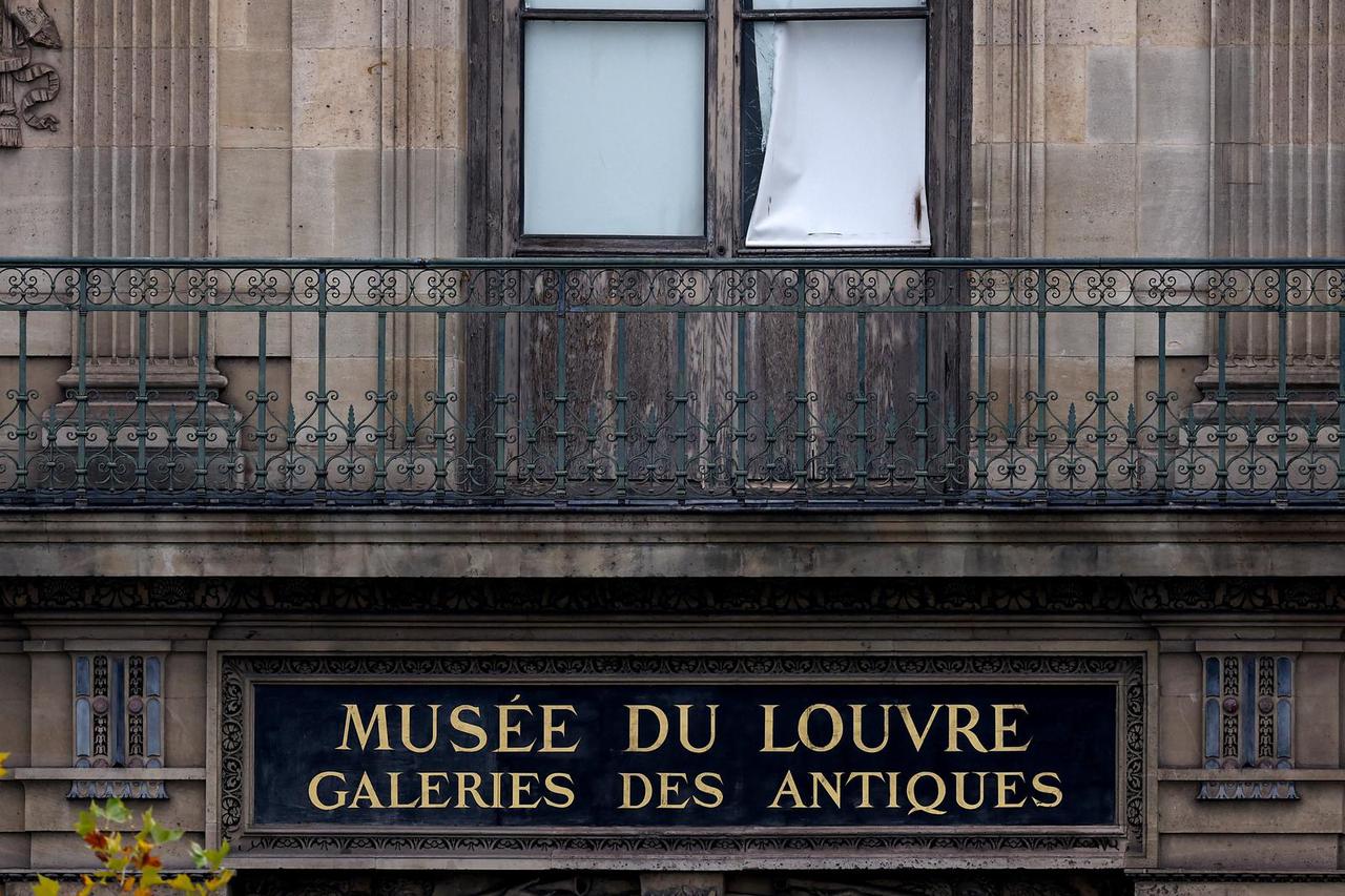 Police stand near the pyramid of the Louvre museum after reports of a robbery, in Paris