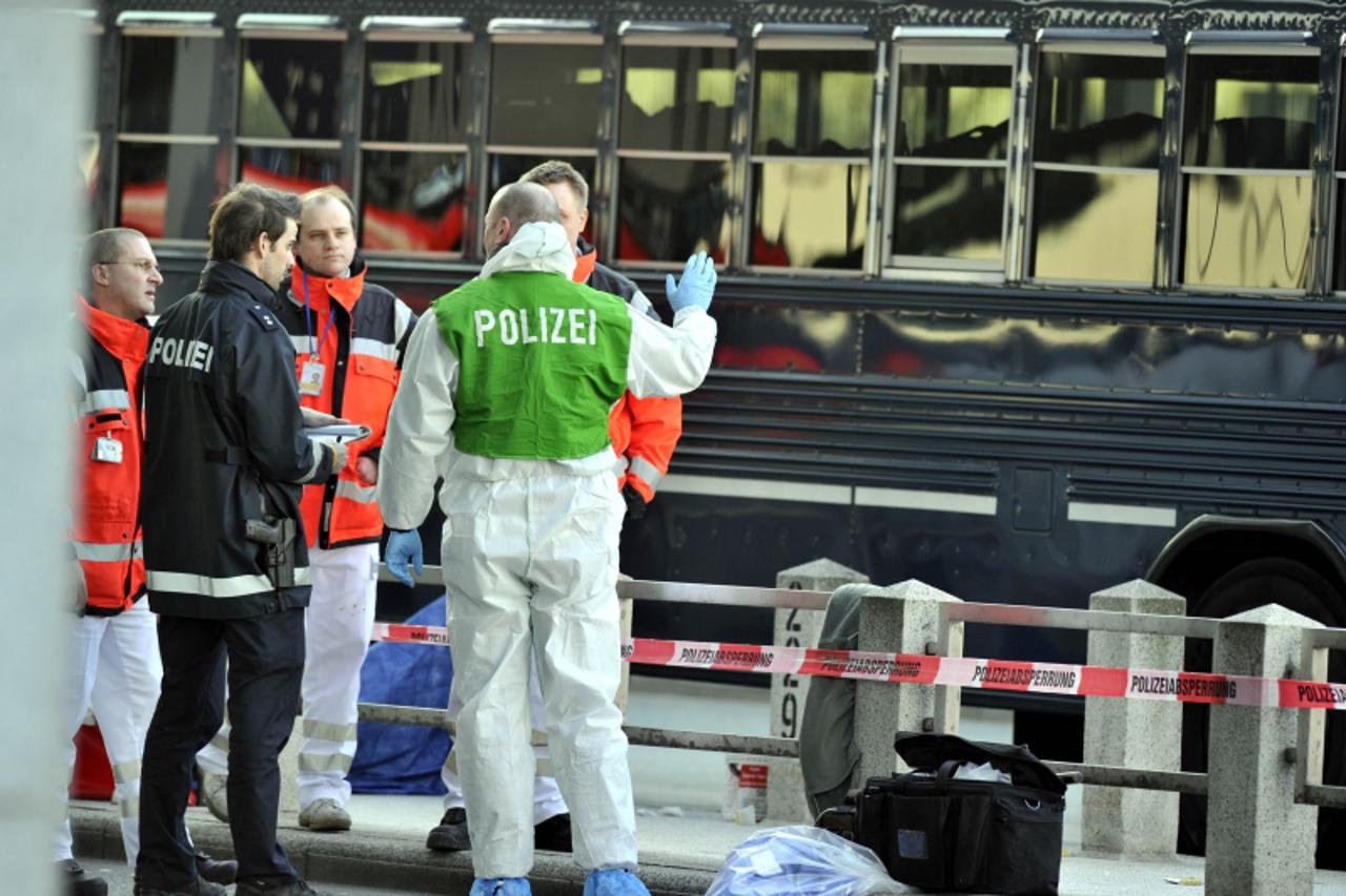 'Policemen and ambulance men stand in front of a US military bus after a shooting on March 2, 2011 at the airport in Frankfurt/M., western Germany. Two people were killed and two seriously injured in 