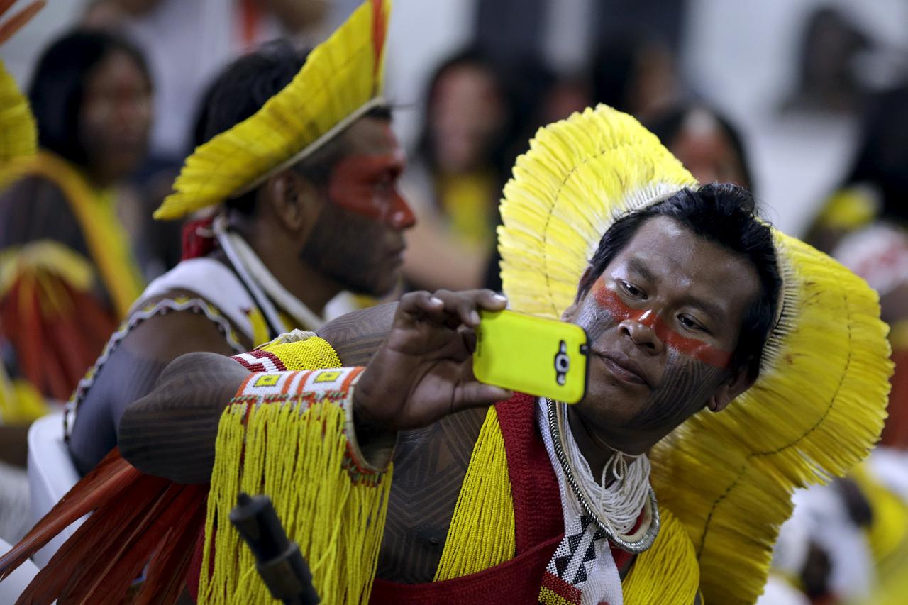 An indigenous man from the Kayapo tribe takes a picture as he arrives to participate in the I World Games for Indigenous People in Palmas, Brazil, October 20, 2015. REUTERS/Ueslei Marcelino