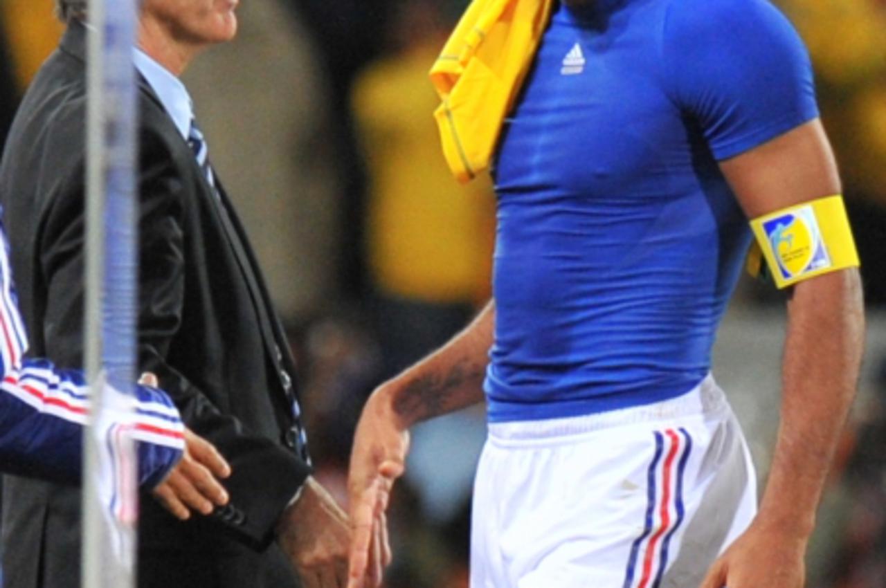 'France\'s striker Thierry Henry leaves the pitch after shaking hands with France\'s coach Raymond Domenech at the end of the Group A first round 2010 World Cup football match France vs. South Africa 