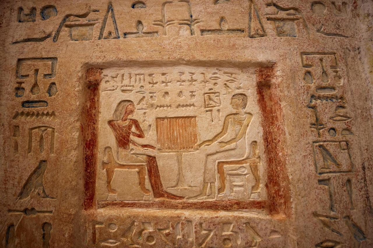 A man sits inside a tomb after the announcement of 4,300-year-old sealed tombs discovered in Egypt's Saqqara necropolis, in Giza