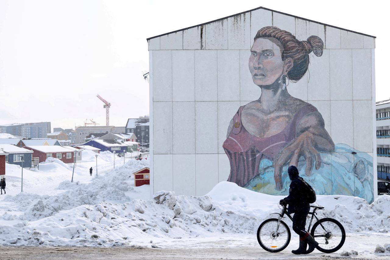 FILE PHOTO: People pass buildings with social housings with an Inuit mural in Nuuk