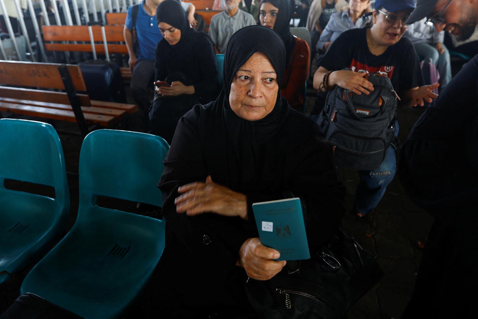 A woman sits holding her passport as Palestinians with dual citizenship wait for permission to leave Gaza, amid the ongoing conflict between Israel and Palestinian Islamist group Hamas, at the Rafah border crossing with Egypt, in Rafah in the southern Gaza Strip, November 2, 2023. REUTERS/Ibraheem Abu Mustafa Photo: IBRAHEEM ABU MUSTAFA/REUTERS