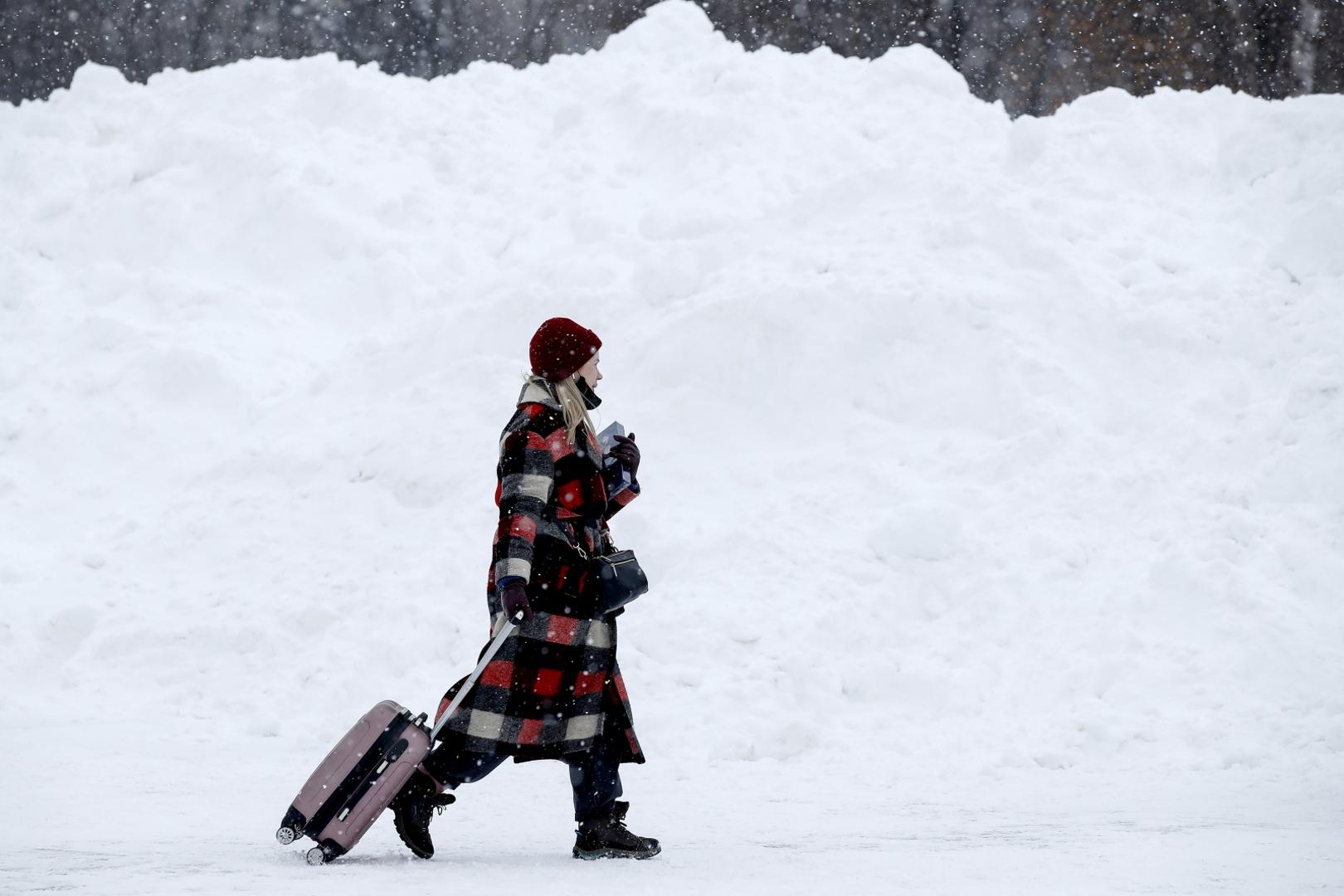MOSCOW, RUSSIA - FEBRUARY 13, 2021: A woman walks past banks of snow outside the VDNKh Exhibition Centre. Artyom Geodakyan/TASS Photo via Newscom Newscom/PIXSELL