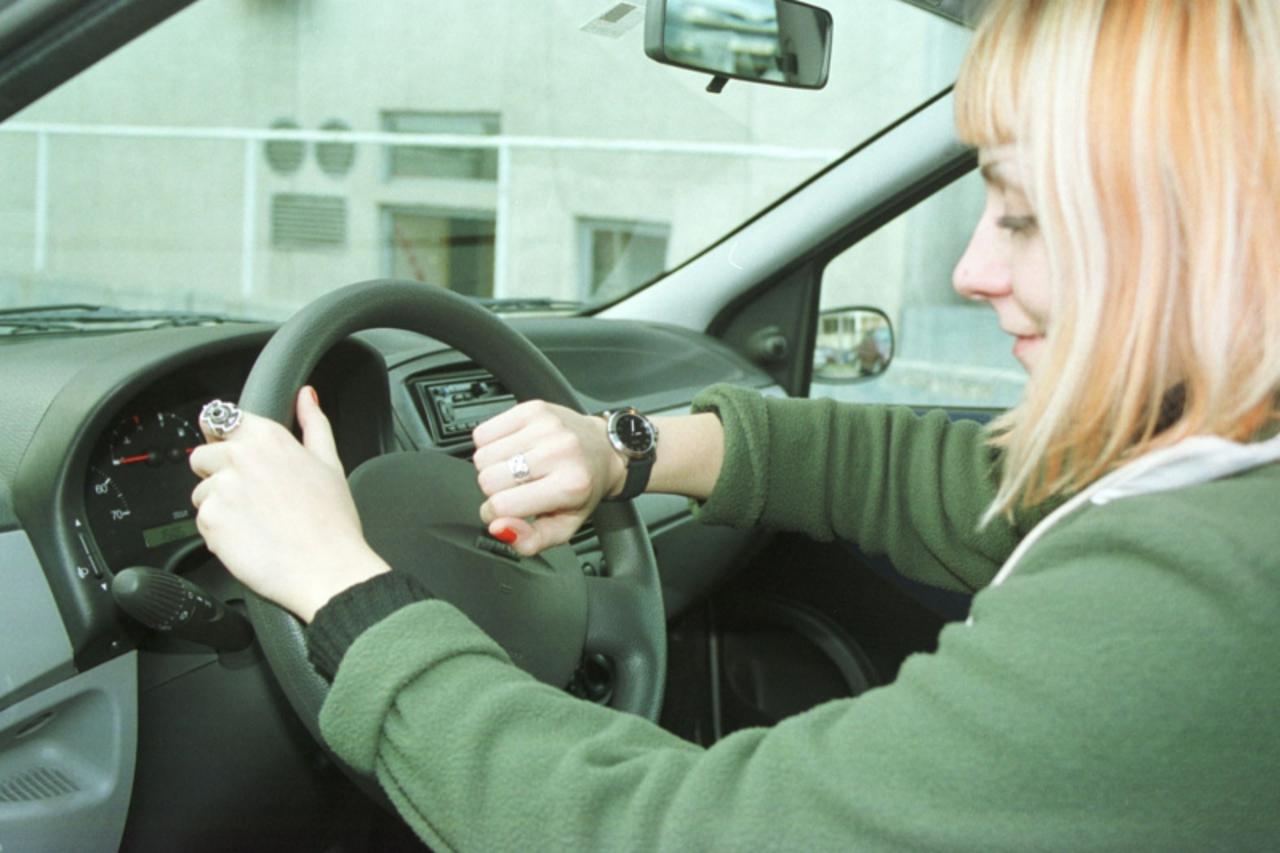 'prva....zagreb....02.01.2001. ilustracija-mlada vozacica za volanom gleda na sat zbog novog zakona koji zabranjuje mladim vozacima da voze nocu snimio-zeljko lukunic'
