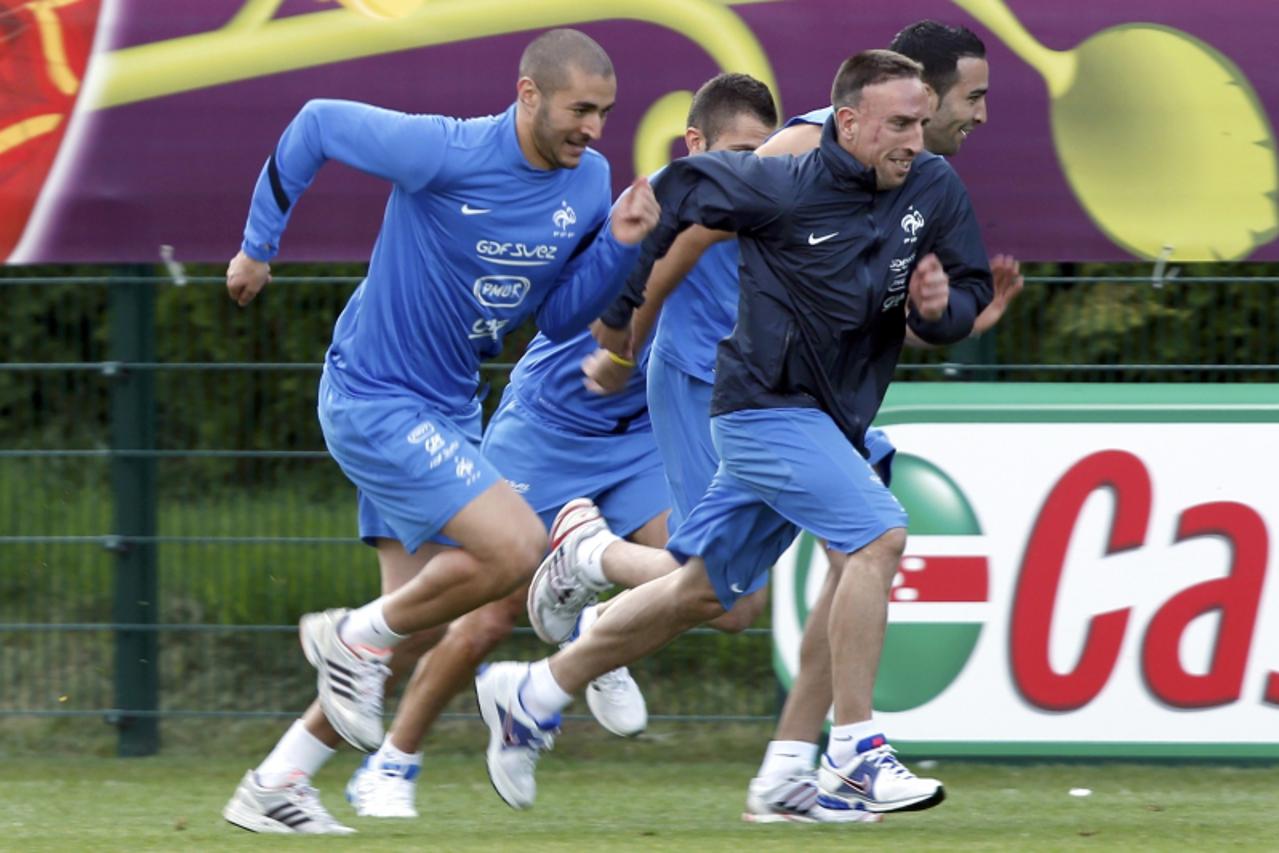 'France\'s soccer players Karim Benzema (L) and Franck Ribery  run during a training session at the team\'s training center in Kircha near Donetsk June 16, 2012. France defeated Ukraine yesterday in t