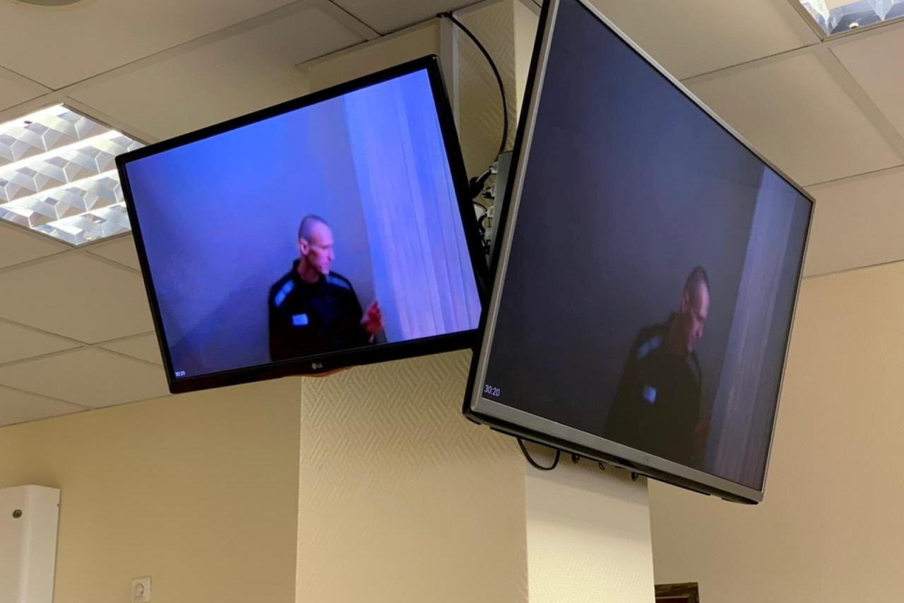 Russian opposition leader Alexei Navalny is seen on screens via video link before a court hearing in Moscow