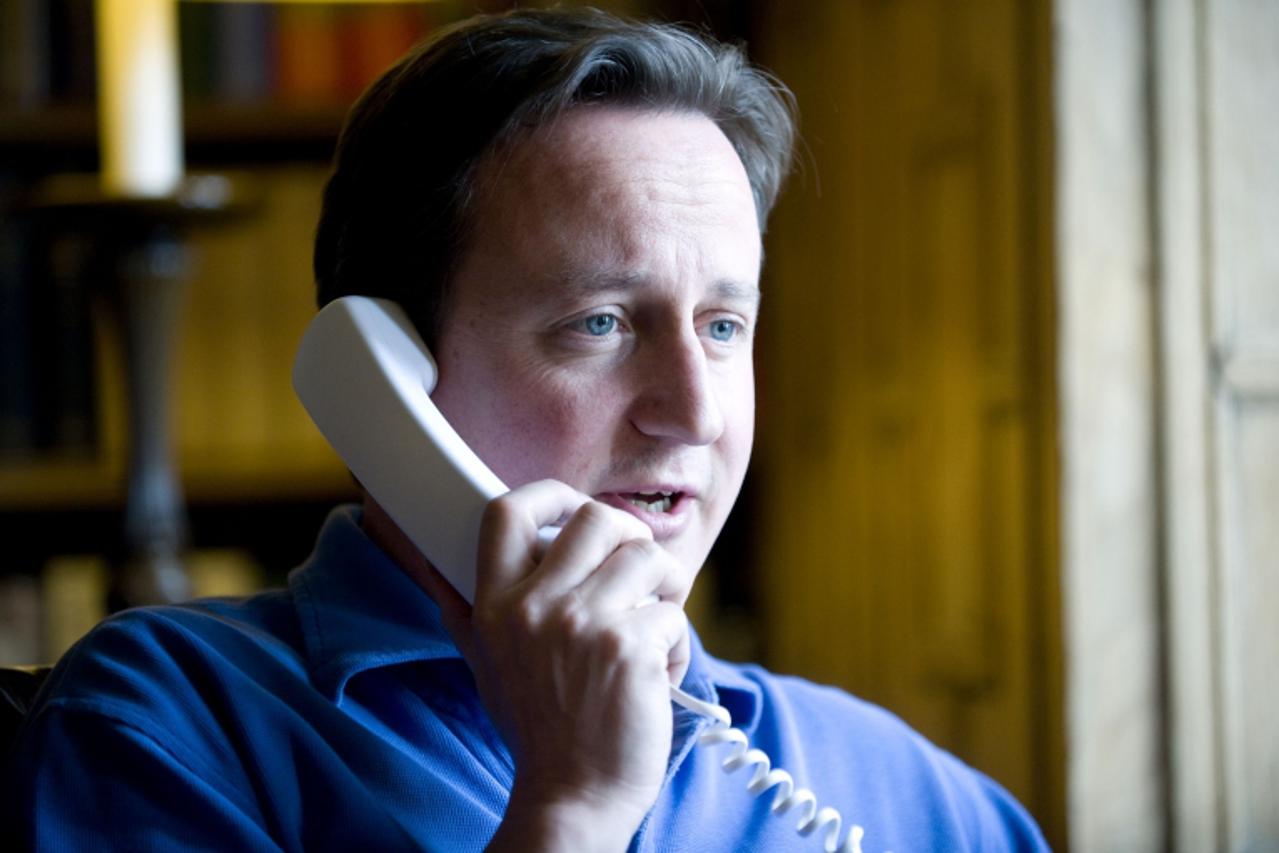 'Britain\'s Prime Minister David Cameron talks to U.S. President Barack Obama on the phone in his office at his official country residence of Chequers outside London June 12, 2010. Cameron will make h