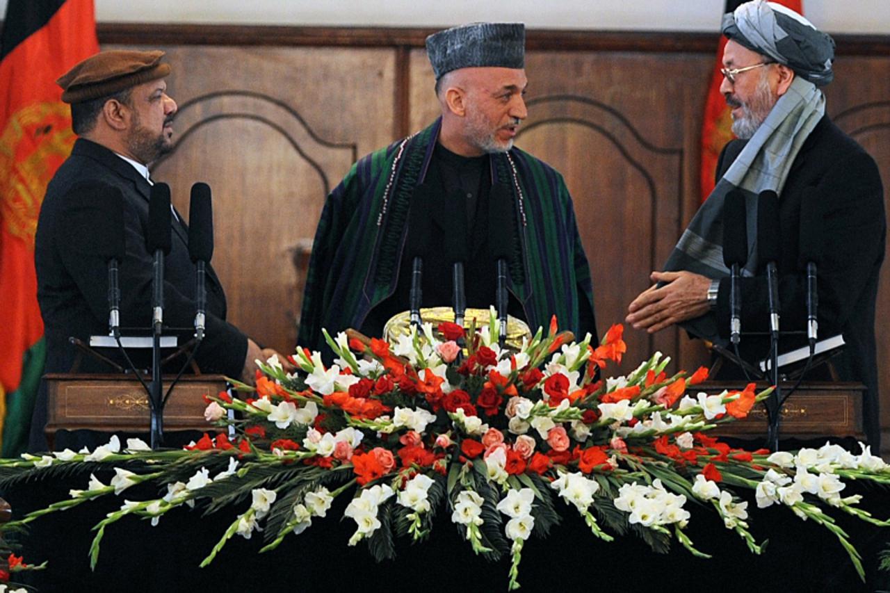 'Afghan President Hamid Karzai (C) talks with his vice president Karim Khalili (R) as other vice president Mohammad Qasim Fahim (L) looks on after being sworn in to their respective posts for the next