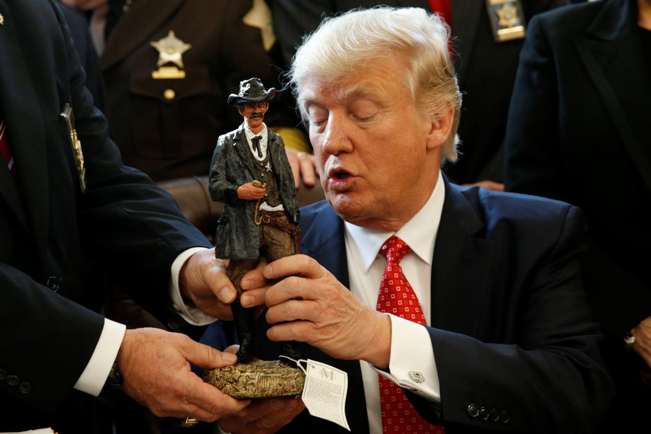 U.S. President Donald Trump receives a figurine of a sheriff during a meeting with county sheriffs at the White House in Washington, U.S. February 7, 2017.  REUTERS/Kevin Lamarque