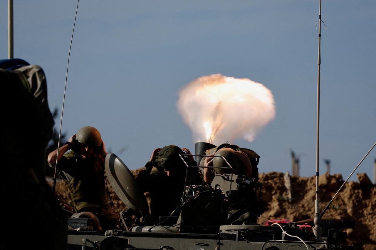 Israeli soldiers fire a mortar as the conflict continues between Israel and Hamas