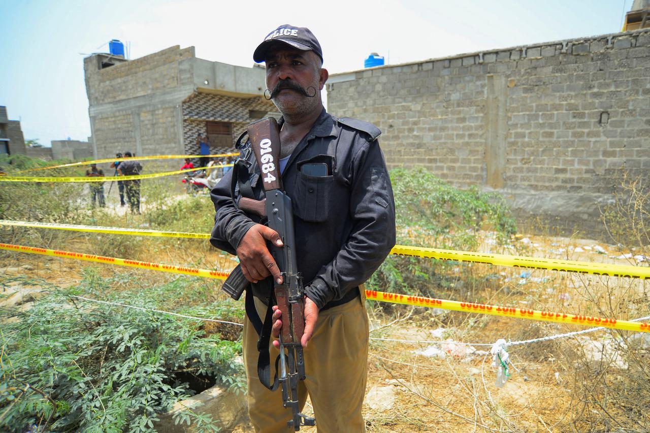 A police officer guards a cordoned area, after according to the Crime Scene Unit (CSU), a drone was brought down on the outskirts of Karachi