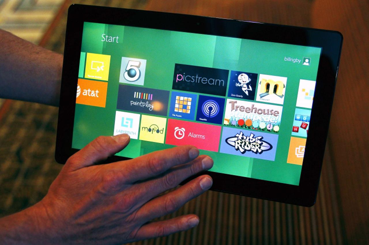 'A Reuters reporter runs through a new test Microsoft Windows tablet running a version of its touch-enabled Windows 8, expected to be released in 2012, at the Build conference in Anaheim, California S