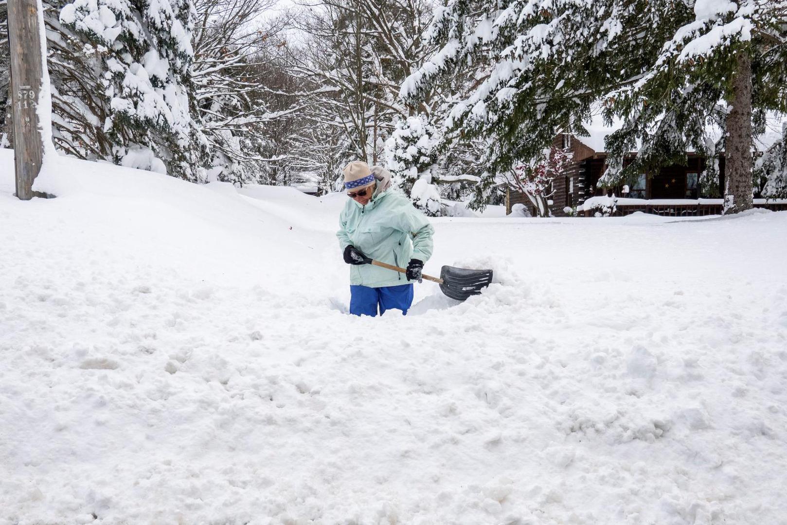 Carol Schuster clears a path in her driveway during a break in the snow storm hitting the Buffalo area, in Orchard Park, New York, U.S. November 19, 2022 REUTERS/Carlos Osorio Photo: Carlos Osorio/REUTERS