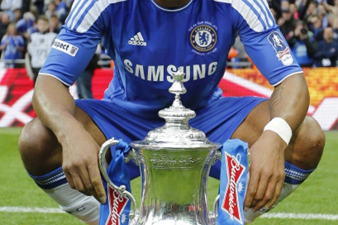 'Chelsea\'s Didier Drogba poses with the trophy after their FA Cup final soccer match against Liverpool at Wembley Stadium in London, May 5, 2012.     REUTERS/Eddie Keogh (BRITAIN - Tags: SPORT SOCCER
