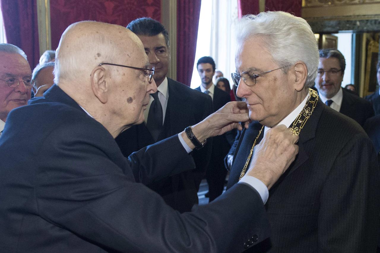 Italy's new President Sergio Mattarella (R) receives a decoration from his predecessor Sergio Napolitano at the Qurinale presidential palace in Rome in this February 3, 2015 handout photo by the Italian Presidency Press Office. REUTERS/Italian Presidency 