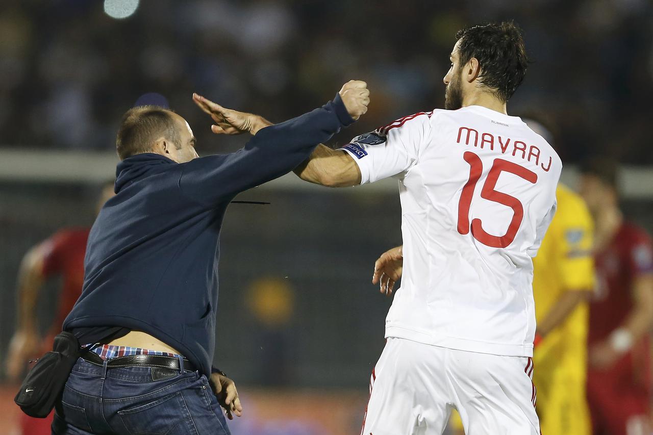 A fan of Serbia scuffles with Albania's Mergim Mavraj during their Euro 2016 Group I qualifying soccer match at the FK Partizan stadium in Belgrade October 14, 2014. The politically-sensitive Euro 2016 qualifier between Serbia and Albania was abandoned on