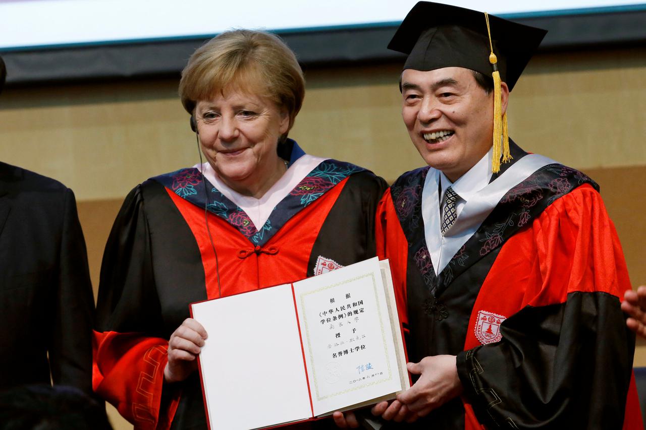 German Chancellor Angela Merkel (L) receives a honorary doctorate degree from Nanjing University's president Chen Jun at University of Chinese Academy of Sciences in Beijing, China, June 12, 2016. REUTERS/Kim Kyung-Hoon