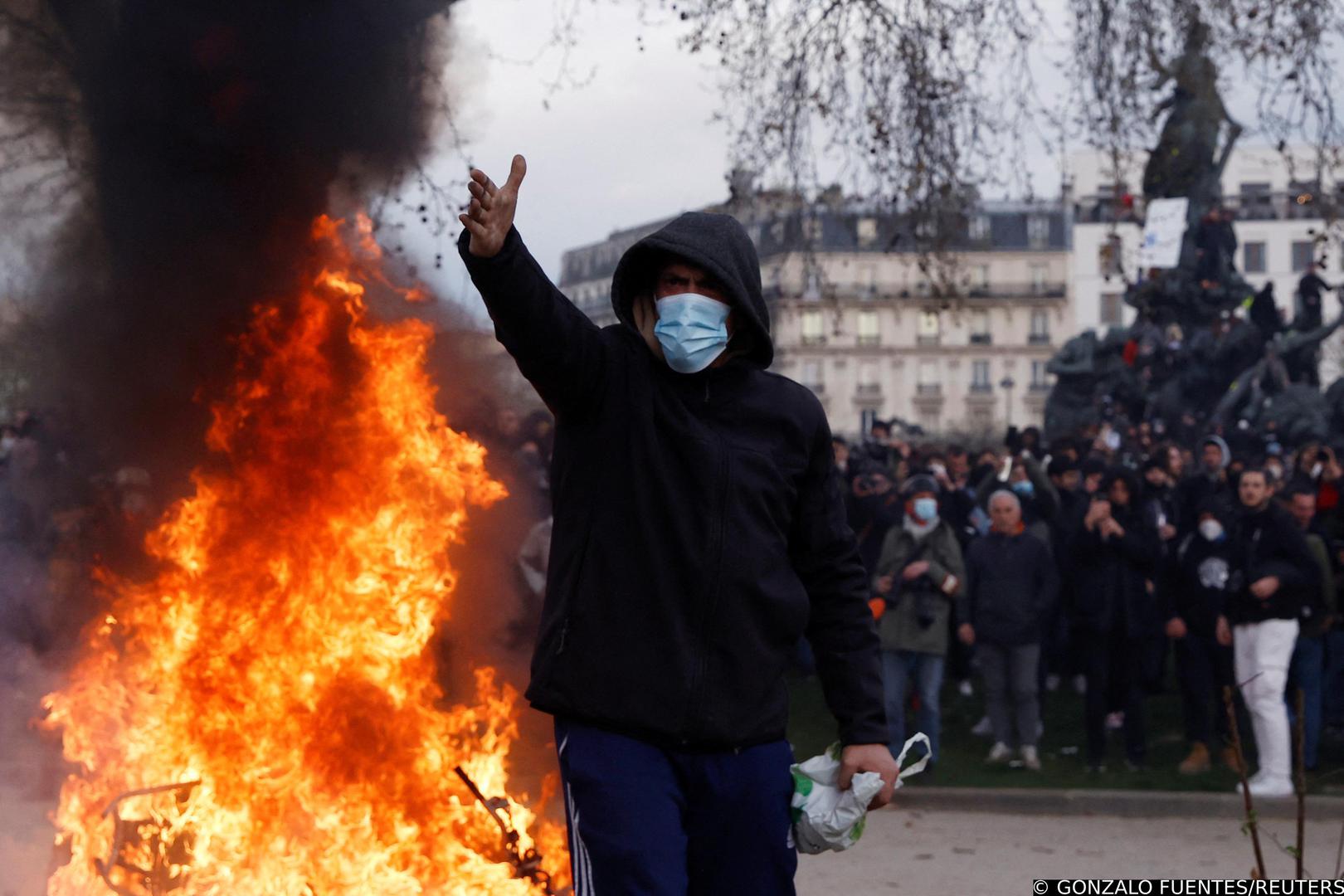 A masked protester reacts near a fire during clashes at a demonstration as part of the tenth day of nationwide strikes and protests against French government's pension reform, in Paris, France, March 28, 2023. REUTERS/Gonzalo Fuentes Photo: GONZALO FUENTES/REUTERS