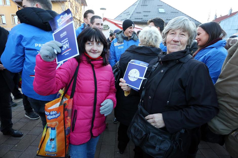 Kolinda je u kampanji kao zvijezda, kažu i njezini iz autobusa – kao da smo na turneji Miše Kovača. Sve je brzo, govori su kratki, a s ljudima se rukuje u hodu. Žuri