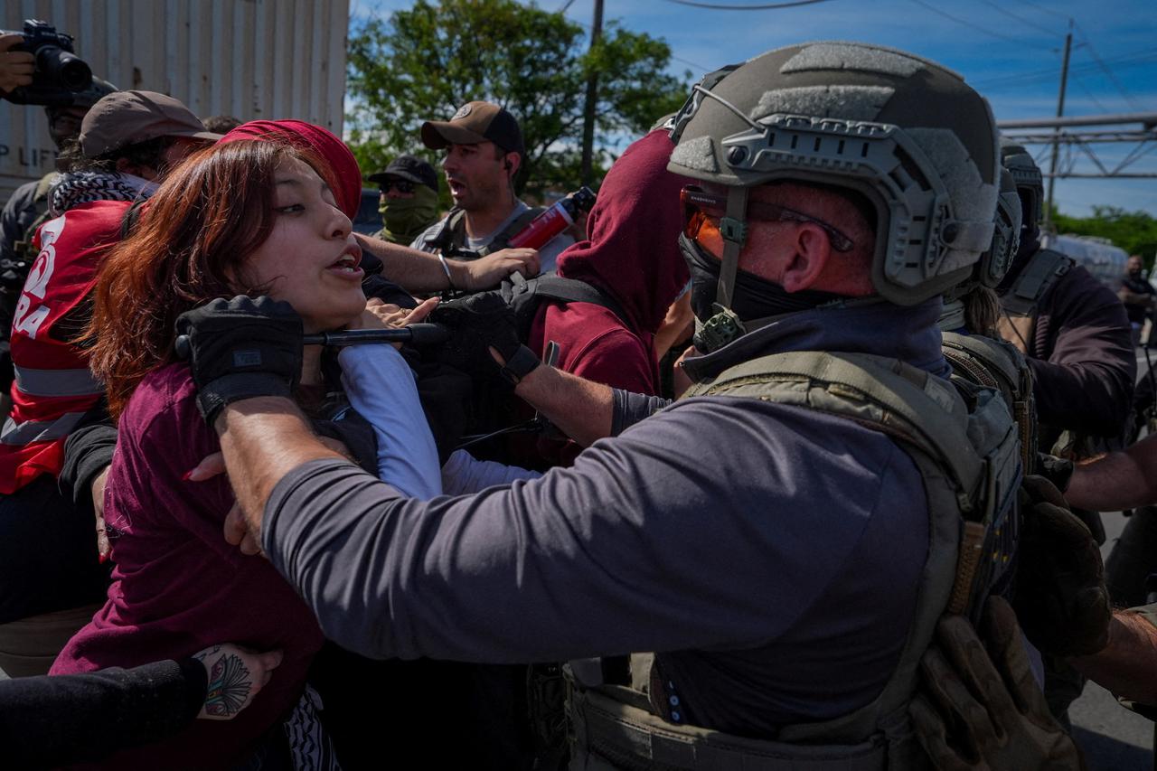 Protesters demonstrate in front of ICE officers outside Delaney Hall in Newark